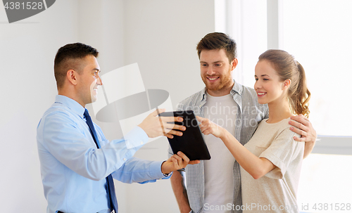 Image of couple and realtor with tablet pc at new home