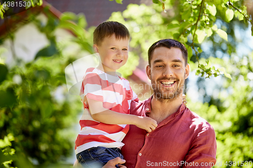 Image of happy father and son at summer garden