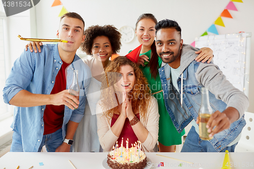 Image of happy coworkers with cake at office birthday party