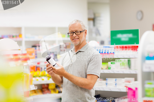 Image of senior male customer with drug at pharmacy