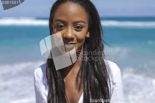 Image of Cheerful black young woman at ocean