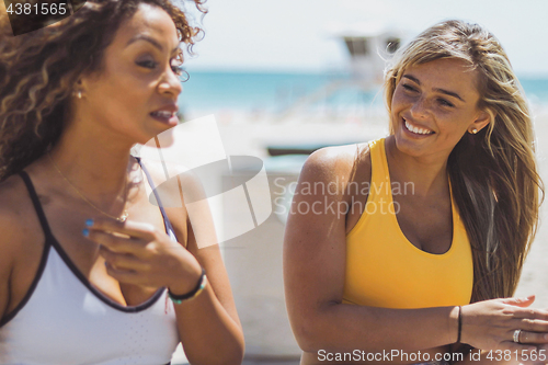 Image of Excited sportive girls relaxing on shore