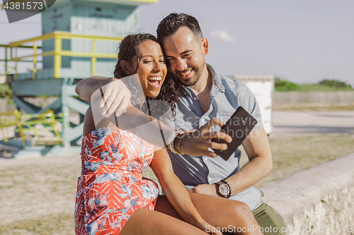 Image of Excited couple taking selfie on seafront