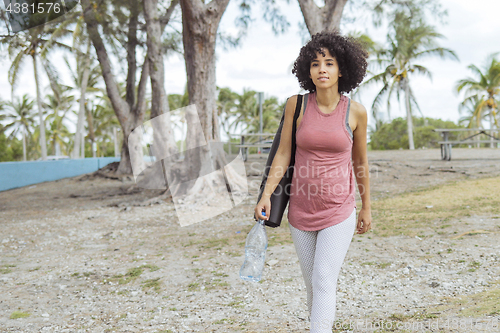 Image of Relaxed girl with water and yoga mat