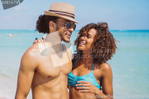 Image of Couple standing and embracing at oceanside