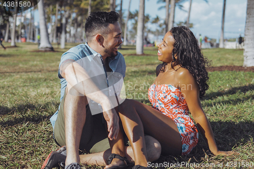 Image of Content diverse couple chilling on green meadow