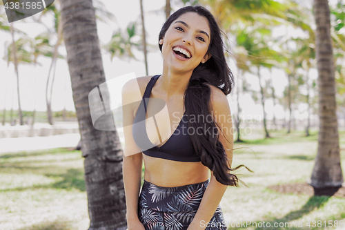 Image of Ethnic laughing sportswoman looking at camera outside