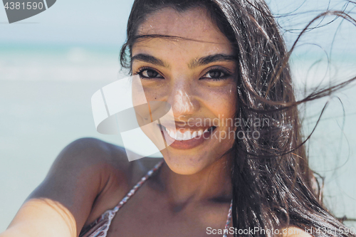 Image of Charming ethnic woman on windy beach