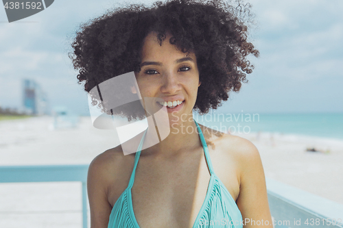 Image of Cheerful black woman in sunlight on beach