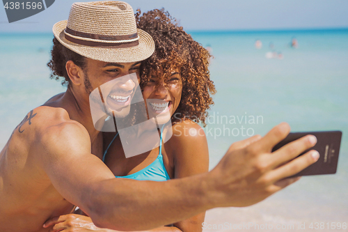 Image of Cheerful happy couple selfies on beach