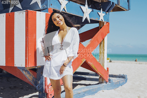 Image of Content pretty woman posing confidently on beach