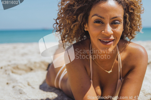 Image of Pretty woman in bikini lying on beach