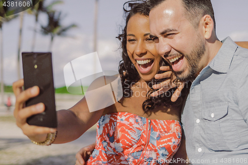 Image of Diverse bright couple taking selfie