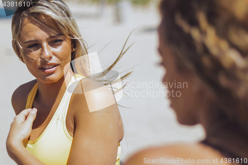 Image of Pretty sportive women talking on beach