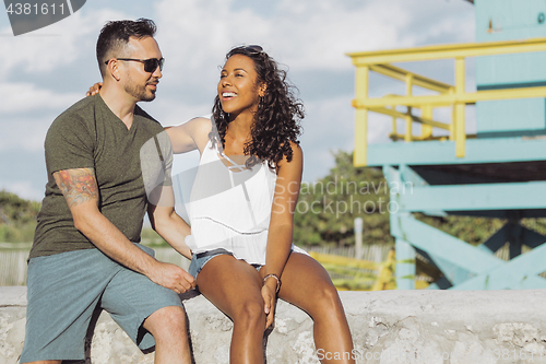 Image of Laughing stylish couple on seafront