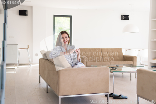 Image of young woman in a bathrobe enjoying morning coffee