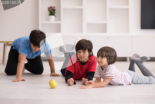 Image of boys having fun with an apple on the floor