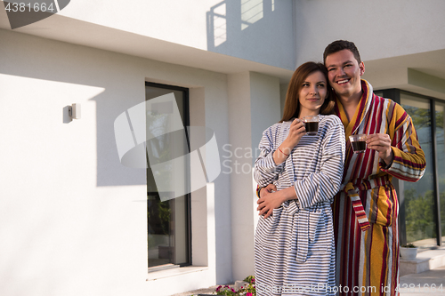 Image of Young beautiful couple in bathrobes