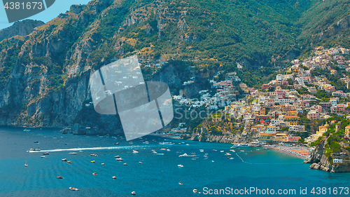 Image of One of the best resorts of Italy with old colorful villas on the steep slope, nice beach, numerous yachts and boats in harbor and medieval towers along the coast, Positano.