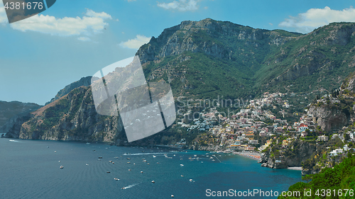 Image of One of the best resorts of Italy with old colorful villas on the steep slope, nice beach, numerous yachts and boats in harbor and medieval towers along the coast, Positano.