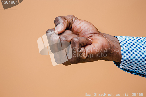 Image of Male black fist isolated on brown background. African american clenched hand, gesturing up