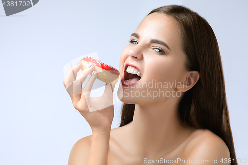 Image of beautiful woman biting a donut