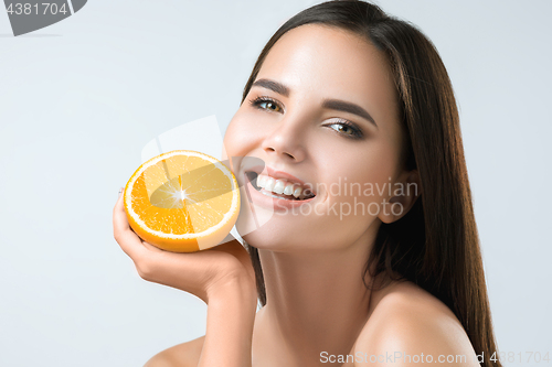 Image of Beautiful woman\'s face with juicy orange