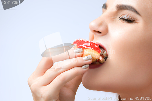 Image of beautiful woman biting a donut