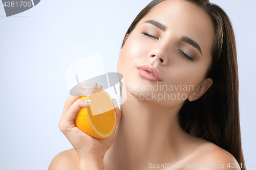 Image of Beautiful woman\'s face with juicy orange