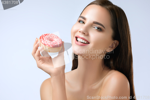 Image of beautiful woman biting a donut