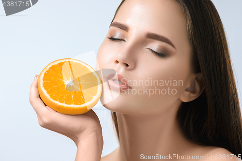 Image of Beautiful woman\'s face with juicy orange