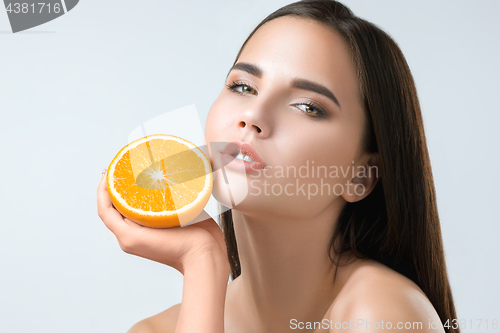 Image of Beautiful woman\'s face with juicy orange