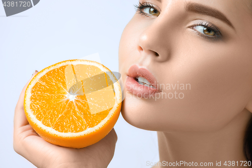 Image of Beautiful woman\'s face with juicy orange