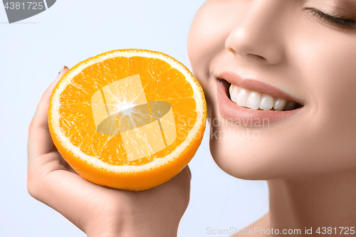 Image of Beautiful woman\'s face with juicy orange