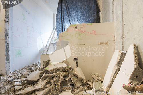 Image of Dismantling of partitions in the apartment, around a heap of broken parts of the wall