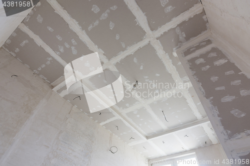 Image of The ceiling of the room, covered with plasterboard sheets, and putty stitches