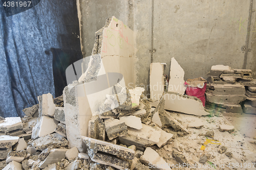 Image of Broken parts of the wall lie around the wall being dismantled