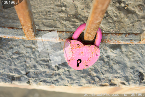 Image of Rusty wedding pink castle with the inscription \"advice and love\" hanging on the fence of the fence