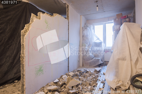 Image of Reshaping the apartment. Dismantling of walls. Things are covered with a cloth for protection from dust