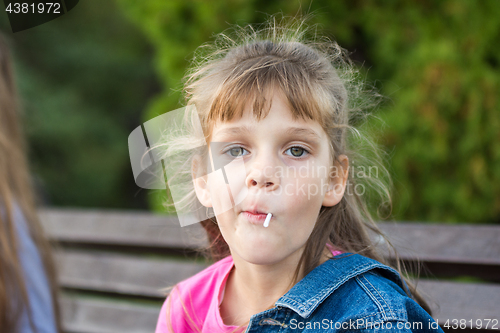 Image of Portrait of a six-year-old gay girl who sucks a lollipop