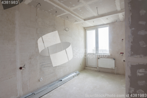 Image of Interior of the renovated room in a new building, plastered walls, mounted ceiling and cabinet