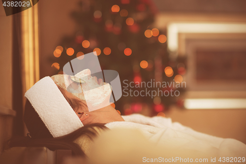 Image of woman is getting facial clay mask at spa