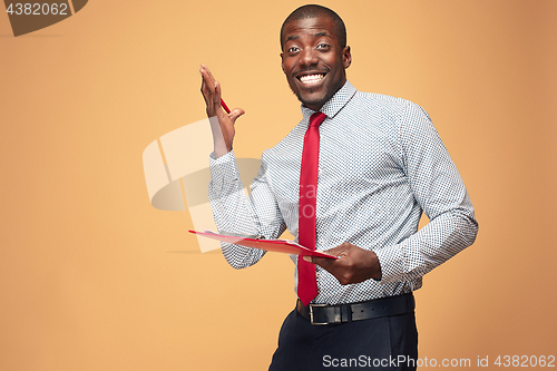 Image of Attractive standing Afro-American businessman writing notes