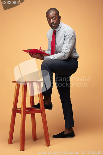 Image of Attractive standing Afro-American businessman writing notes