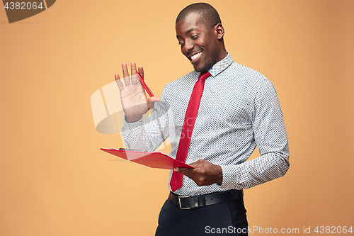 Image of Attractive standing Afro-American businessman writing notes