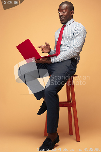 Image of Handsome Afro American man sitting and using a laptop