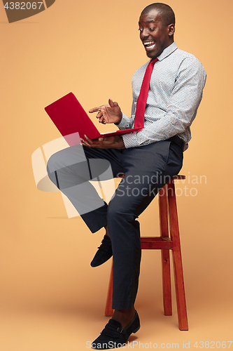 Image of Handsome Afro American man sitting and using a laptop