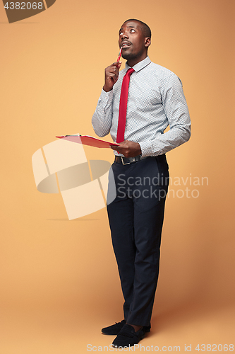 Image of Attractive standing Afro-American businessman writing notes