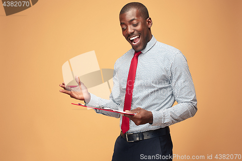 Image of Attractive standing Afro-American businessman writing notes