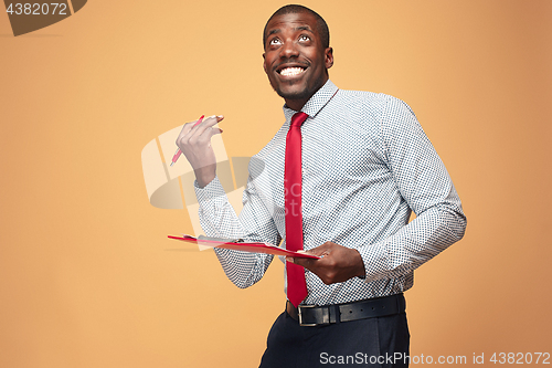 Image of Attractive standing Afro-American businessman writing notes